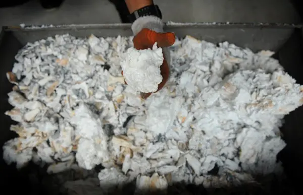Marfim de elefante incinerado é remexido por funcionário do Escritório de Vida Selvagem e Áreas Protegidas das Filipinas, nesta quarta-feira (26). Mais de cinco toneladas do produto que haviam sido apreendidas pelo governo filipino estão sendo destruídas (Foto: Noel Celis/AFP)