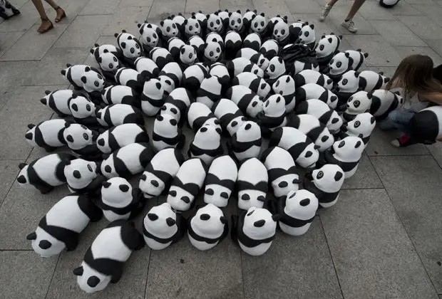 Menina brinca com pandas de brinquedo em estação de trem em Berlim, na Alemanha, nesta segunda-feira (5) (Foto: John Macdougall/AFP)