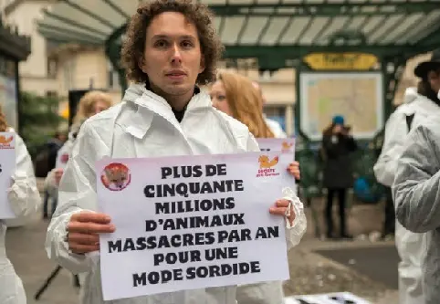 O cartaz diz: "Cinquenta milhões de animais são massacrados por ano por uma moda sórdida" (Foto: AFP)