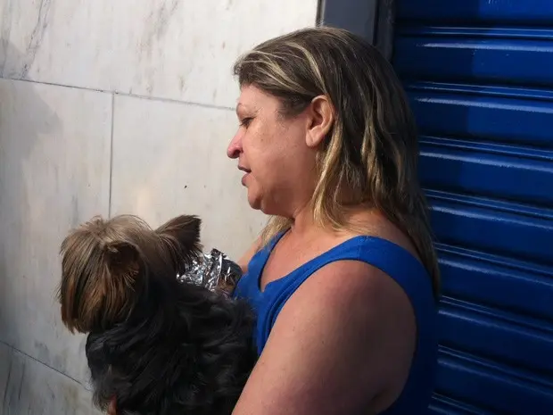 Moradora de prédio esvaziado com seu cachorro (Foto: Letícia Macedo/ G1)