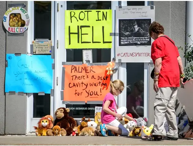 Cartaz com a mensagem ‘apodreça no inferno’ é visto na porta da clínica do dentista Walter Palmer, em Bloomington, Minnesota, na quarta (29) (Foto: Glen Stubbe/Star Tribune via AP)